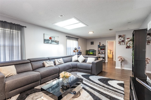 living room featuring dark wood-type flooring and a textured ceiling