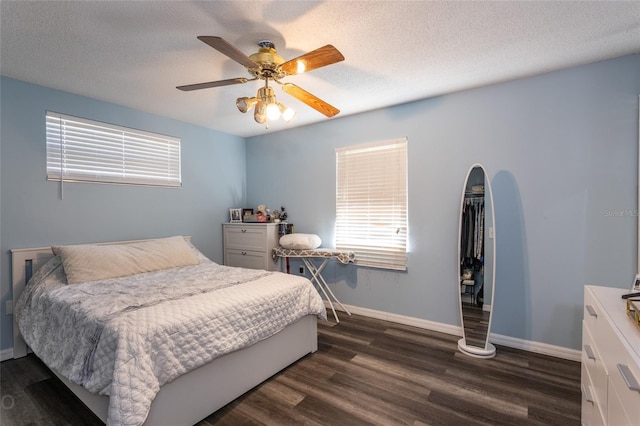 bedroom with a textured ceiling, dark hardwood / wood-style floors, and ceiling fan