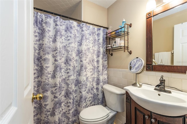 bathroom featuring tile walls, vanity, toilet, and walk in shower