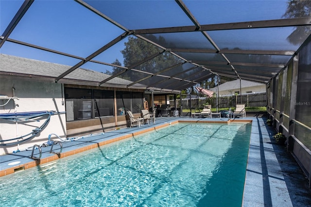 view of pool with a patio area and glass enclosure