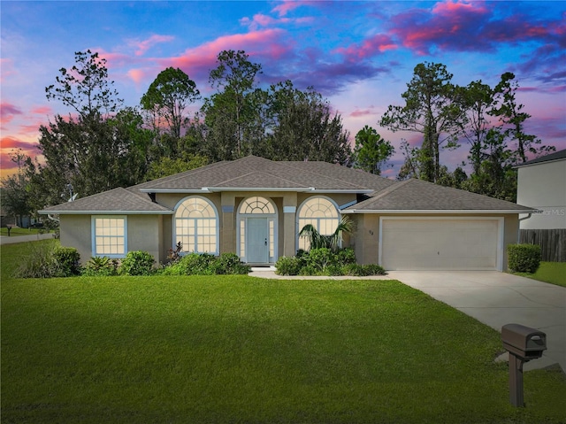 ranch-style home with a yard and a garage