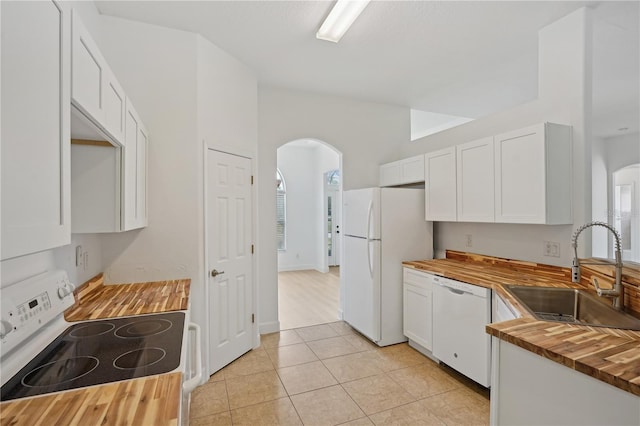 kitchen with white cabinets, butcher block counters, sink, and white appliances