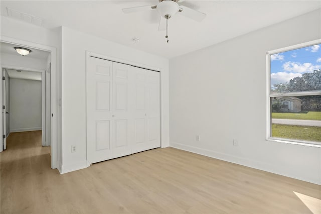 unfurnished bedroom with a closet, light wood-type flooring, and ceiling fan