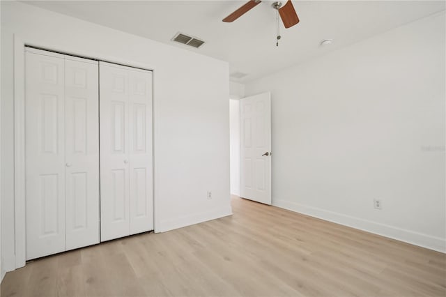 unfurnished bedroom featuring a closet, light hardwood / wood-style floors, and ceiling fan