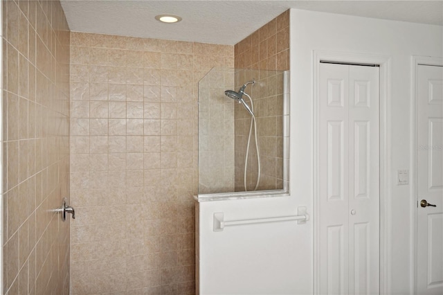 bathroom featuring tiled shower and a textured ceiling