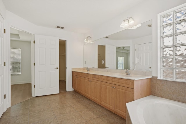 bathroom with vanity, a washtub, and tile patterned flooring