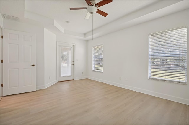 empty room with light hardwood / wood-style floors, a wealth of natural light, and ceiling fan