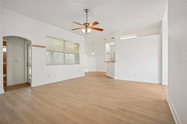 unfurnished living room with light hardwood / wood-style flooring and ceiling fan