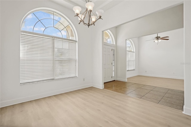 foyer entrance featuring light hardwood / wood-style flooring and ceiling fan with notable chandelier