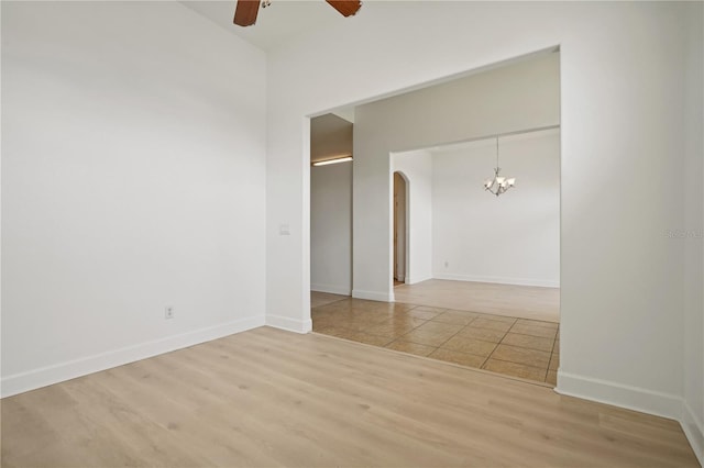 unfurnished room featuring light hardwood / wood-style floors and ceiling fan with notable chandelier