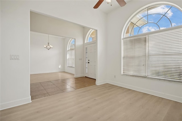 foyer entrance featuring light hardwood / wood-style floors and ceiling fan with notable chandelier