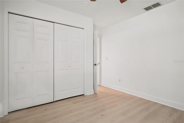 unfurnished bedroom featuring a closet, ceiling fan, and light wood-type flooring