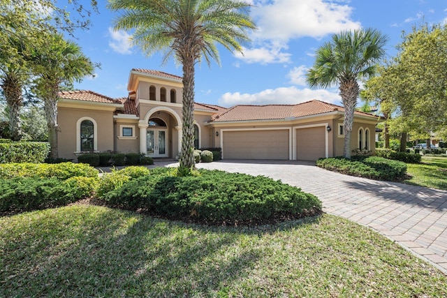 mediterranean / spanish house with a garage and french doors