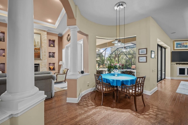 dining room featuring a fireplace, wood-type flooring, and crown molding