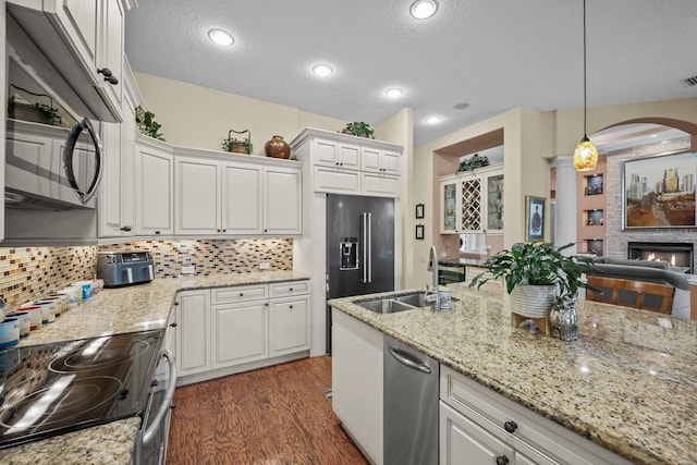 kitchen with dark hardwood / wood-style flooring, a textured ceiling, stainless steel appliances, pendant lighting, and white cabinetry