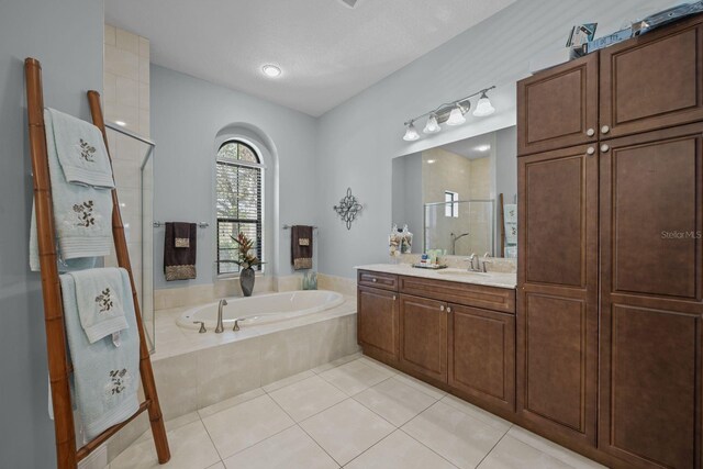 bathroom with vanity, shower with separate bathtub, a textured ceiling, and tile patterned floors