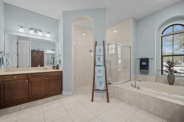 bathroom with tile patterned floors, vanity, and shower with separate bathtub