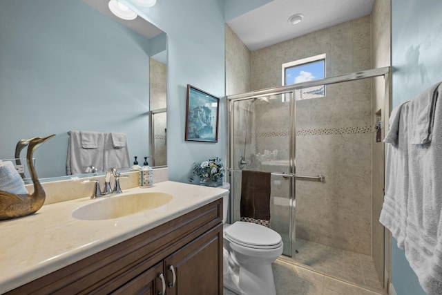 bathroom with tile patterned flooring, vanity, toilet, and walk in shower