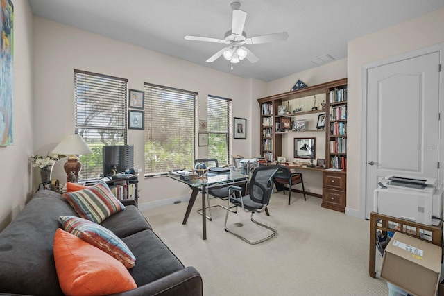 carpeted office space with ceiling fan