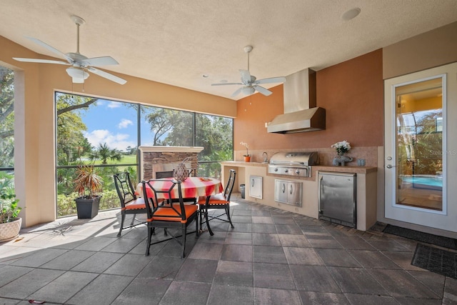 view of patio featuring a grill, ceiling fan, and an outdoor kitchen