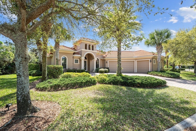 mediterranean / spanish house with a garage and a front yard