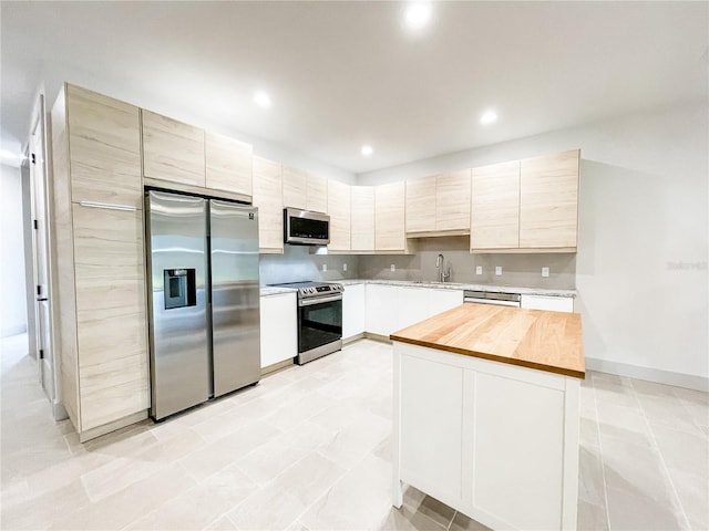 kitchen with butcher block counters, stainless steel appliances, and sink