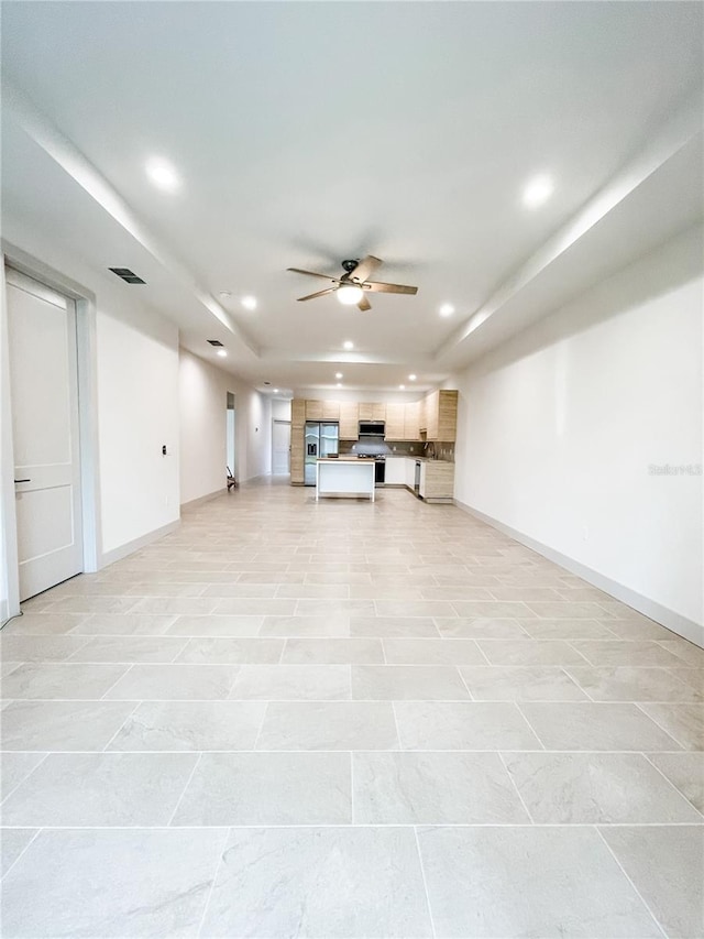 basement featuring stainless steel fridge with ice dispenser and ceiling fan