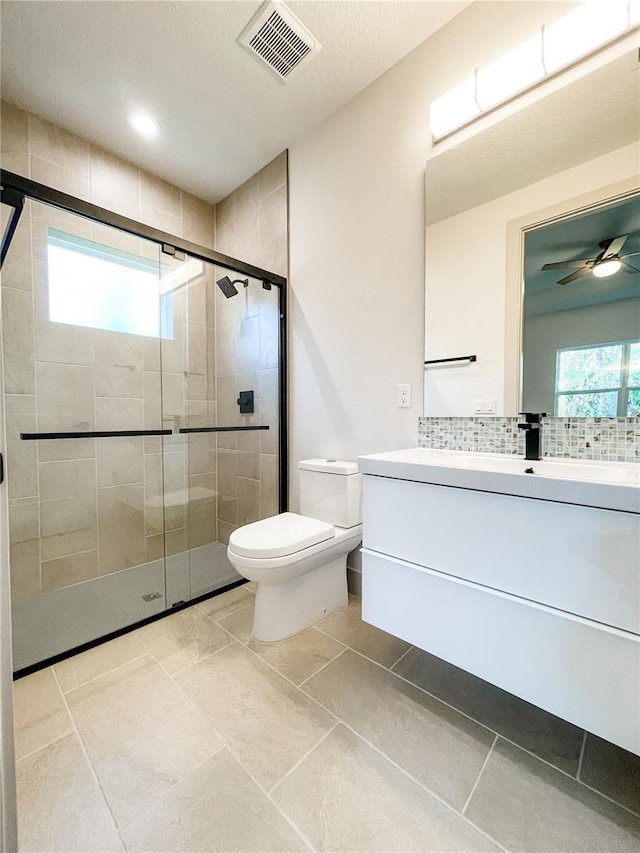 bathroom featuring backsplash, an enclosed shower, toilet, vanity, and tile patterned flooring