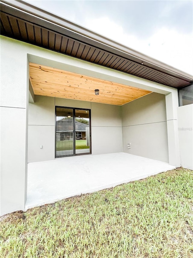 doorway to property featuring a yard and a patio area