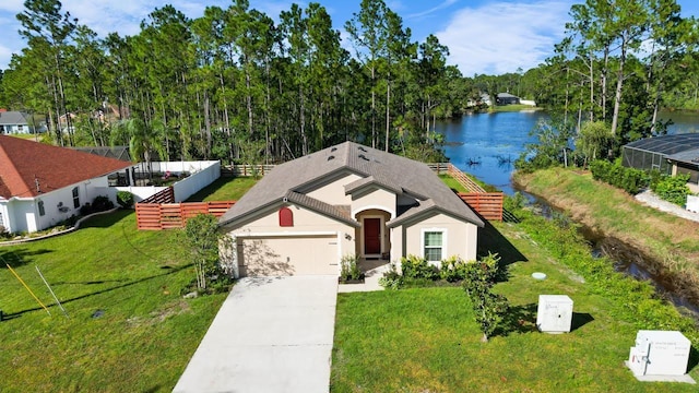 view of front of property with a front yard, a garage, and a water view