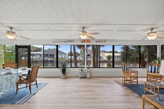 sunroom with beamed ceiling, a water view, and wood ceiling