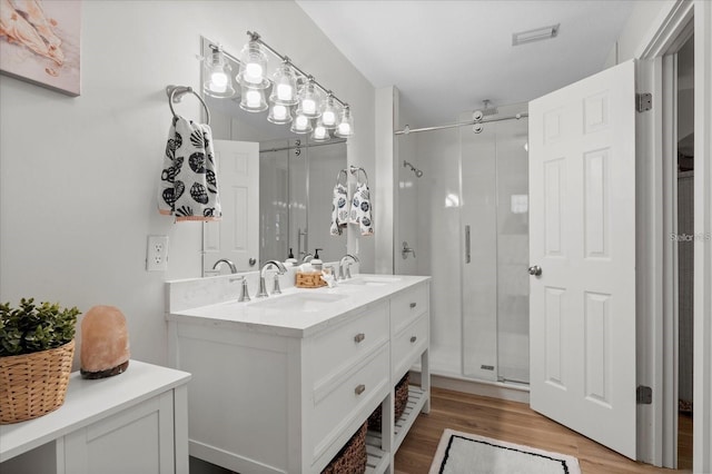 bathroom featuring vanity, wood-type flooring, and walk in shower