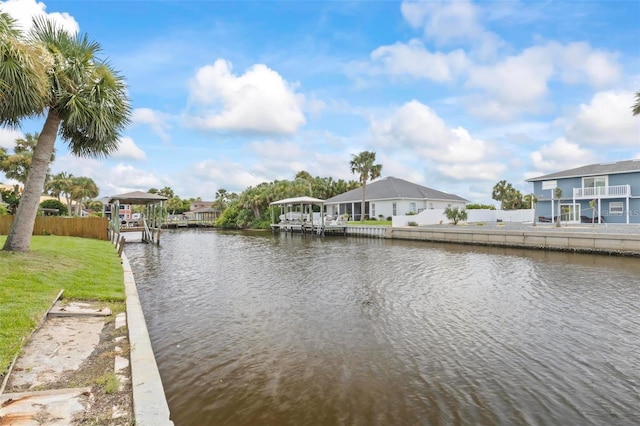 view of dock with a lawn and a water view