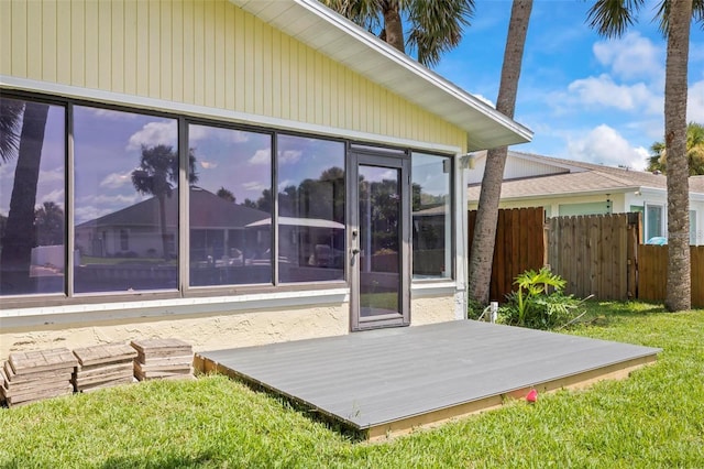 back of property featuring a sunroom and a wooden deck