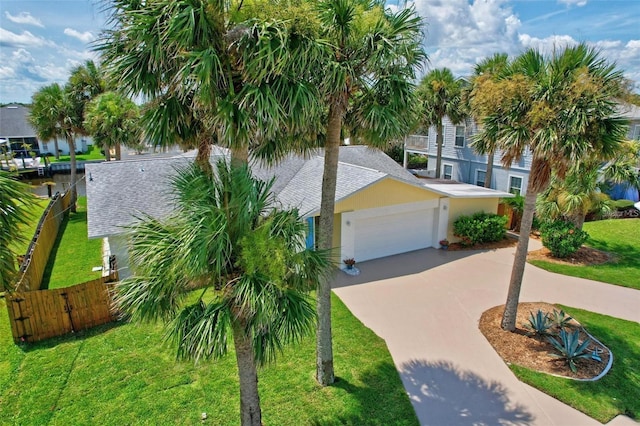 beach home featuring a garage and a front lawn