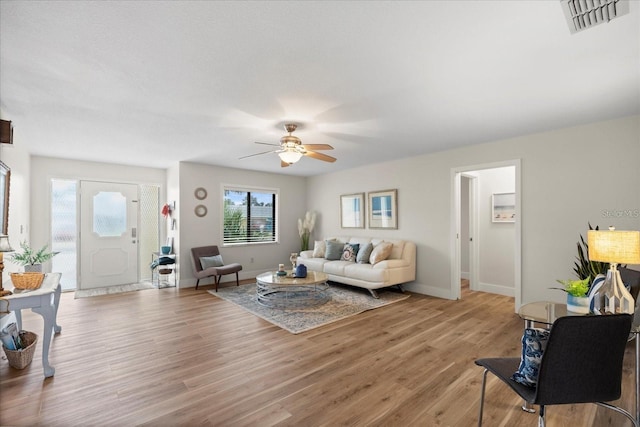 living room featuring ceiling fan and light hardwood / wood-style flooring