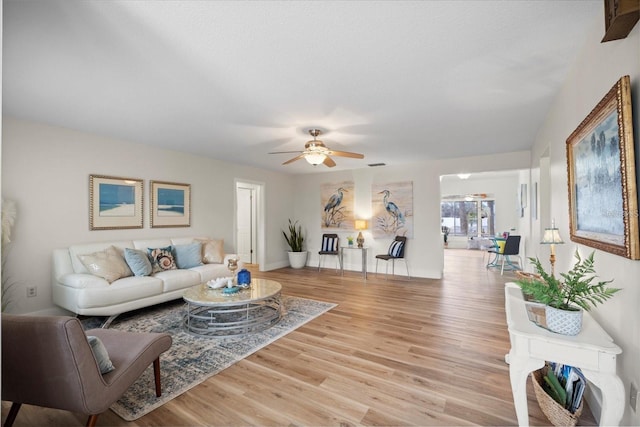 living room with ceiling fan and light wood-type flooring