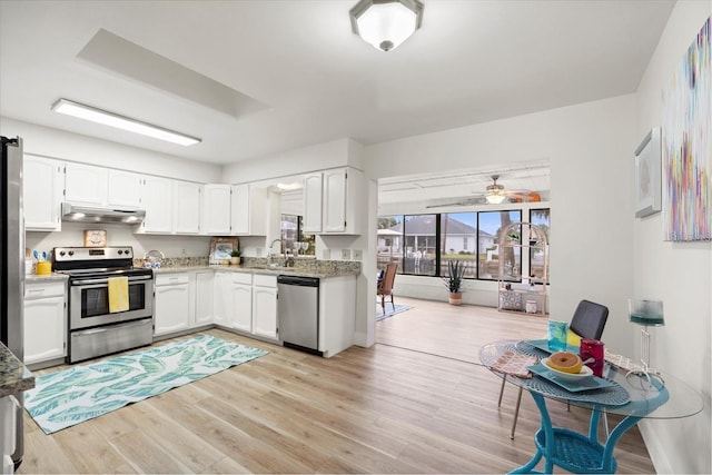 kitchen with white cabinetry, sink, stainless steel appliances, light stone counters, and light hardwood / wood-style floors