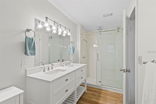 bathroom with vanity, wood-type flooring, and walk in shower