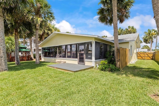 back of house with a sunroom and a yard