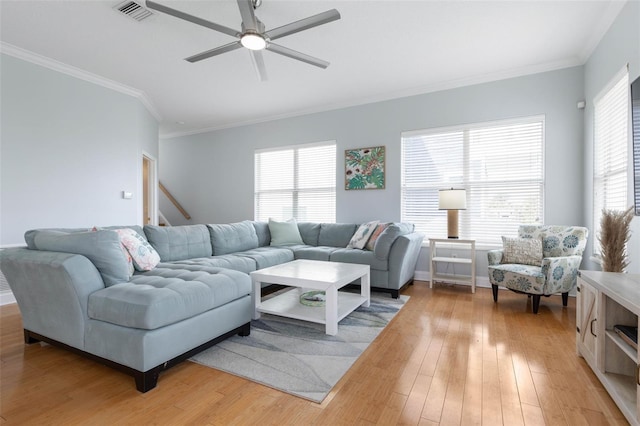 living room featuring crown molding, light hardwood / wood-style flooring, a healthy amount of sunlight, and ceiling fan