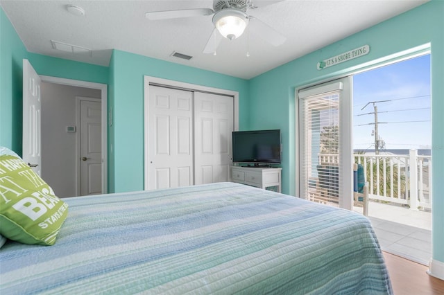 bedroom featuring ceiling fan, access to outside, a textured ceiling, light hardwood / wood-style flooring, and a closet