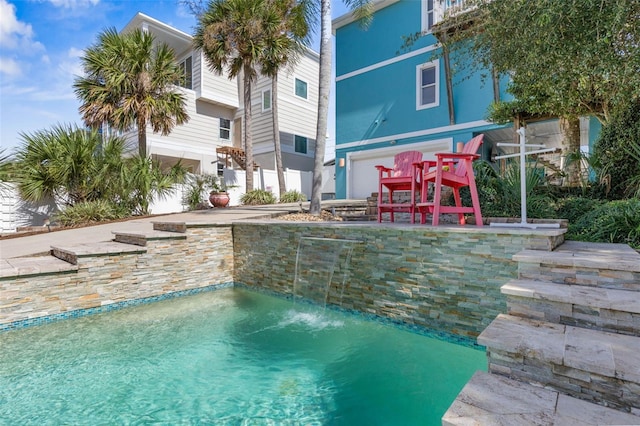 view of pool featuring pool water feature and a patio