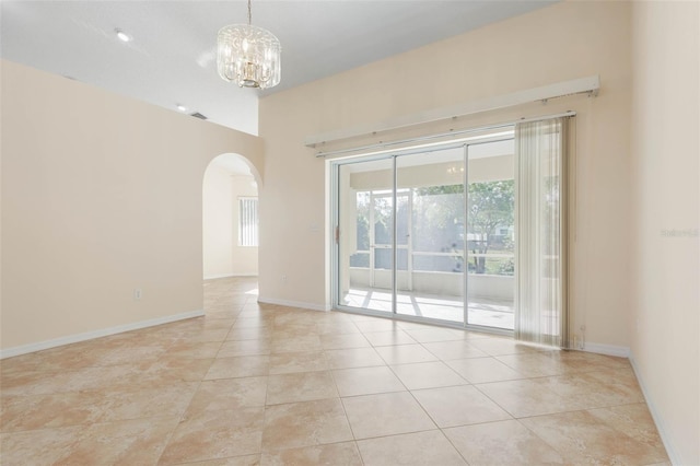 spare room featuring a chandelier and light tile patterned floors