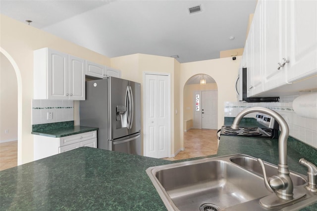 kitchen with decorative backsplash, sink, stainless steel fridge with ice dispenser, light tile patterned floors, and white cabinetry