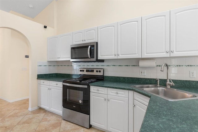 kitchen featuring stainless steel appliances, decorative backsplash, sink, and white cabinets