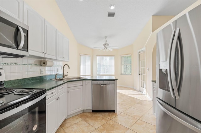 kitchen featuring tasteful backsplash, white cabinetry, light tile patterned flooring, sink, and stainless steel appliances