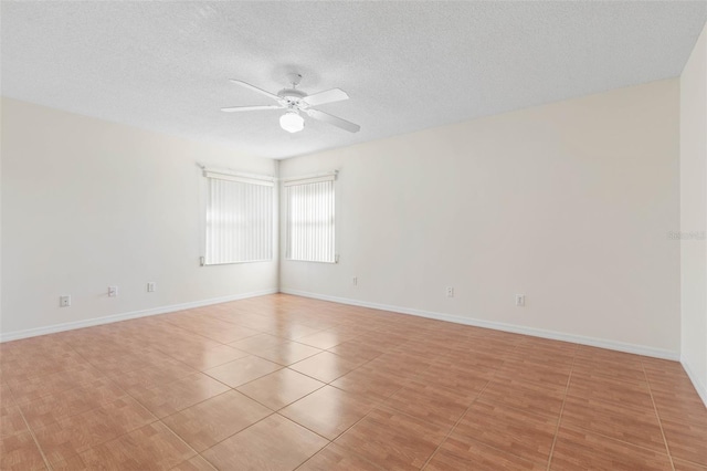 empty room with ceiling fan and a textured ceiling