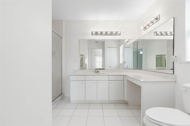 bathroom with toilet, walk in shower, vanity, and tile patterned floors