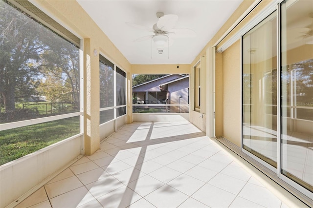 unfurnished sunroom featuring a healthy amount of sunlight and ceiling fan